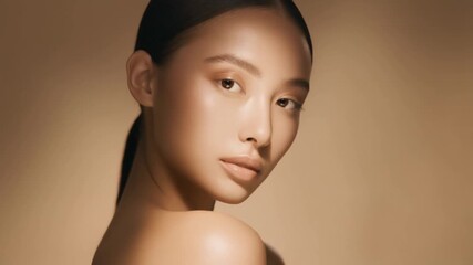 Elegant portrait of a beautiful Asian woman with flawless glowing skin and natural makeup in soft warm light