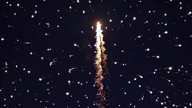 The golden pyrotechnic firework lights up the night sky with dazzling bursts of light, adding a touch of magic to a joyous celebration such as new year's eve or independence day