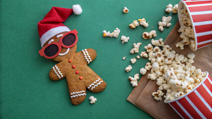 Fun holiday snack scene with gingerbread cookie and popcorn on a green background