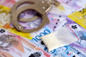 Philippines peso currency money bills and cocaine pack with handcuffs close up. The concept of drug crimes