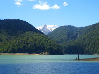 Obraz premium Parque Conguillio rodeado de arboles, montañas, laguna y el Volcán Llaima