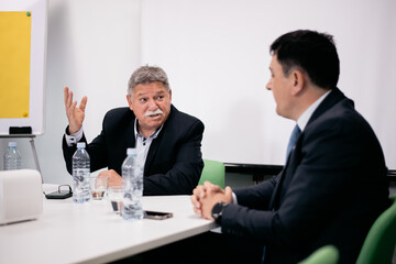 Business professionals discussing strategy during a formal meeting in a modern conference room