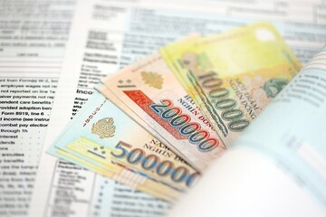 Vietnamese dong money bills on tax form close up. Taxation and accounting concept
