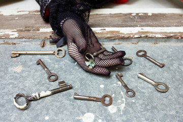 An old key with a bow, a hand in gloves, many antique keys