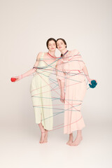 Young twin sisters showcase their unique fashion style in a creative art setting