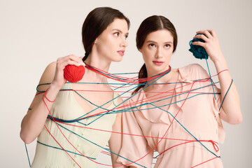 Twin sisters showcase unique fashion in a playful yarn themed artistic display
