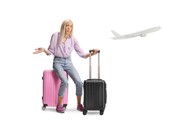 Sad woman sitting on a suitcase and waiting for a plane