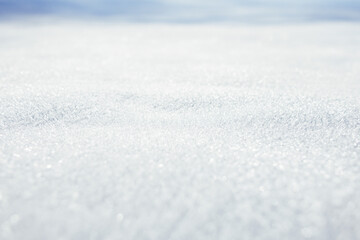 Close-up of sparkling, granular snow or frost texture. Shallow depth of field creates a bright,...