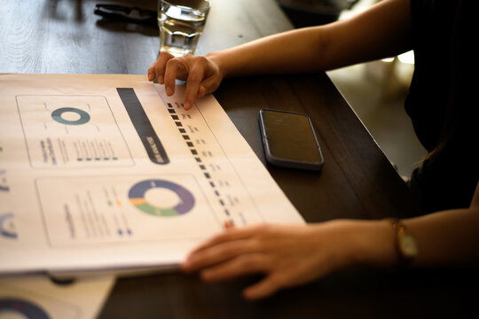 Analyzing business reports at a coffee shop while sipping on a drink