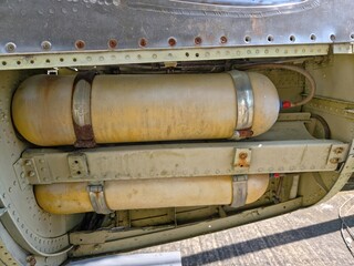 Close-up of two large, cylindrical, pale-yellow auxiliary tanks or containers mounted inside the...