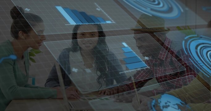 Discussing team leaning over meeting table, pointing at swatches, laptop, holographic charts, hat - Powered by Adobe