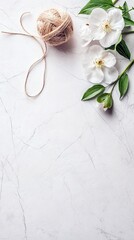 A top-down shot showcases white flowers with green leaves, a ball of twine, and a marble surface. The composition is bright and airy.