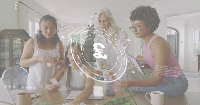 Working women wearing sleeveless tops arranging greenery on wood table in kitchen, laptop pound HUD