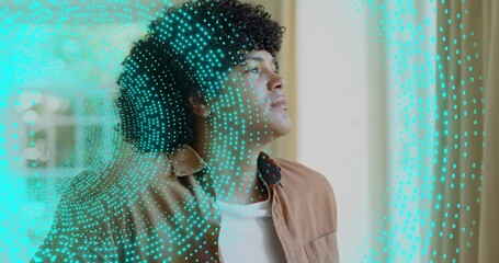 Standing man wearing brown jacket over white tee, gazing at window with turquoise dotted overlay