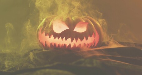 Glowing jack-o'-lantern emitting orange light on tabletop, with yellow-green smoke and draped cloth