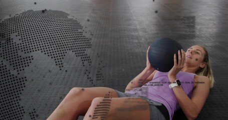 Holding black med ball, woman working core on gym rubber floor, purple top, smartwatch, copy space