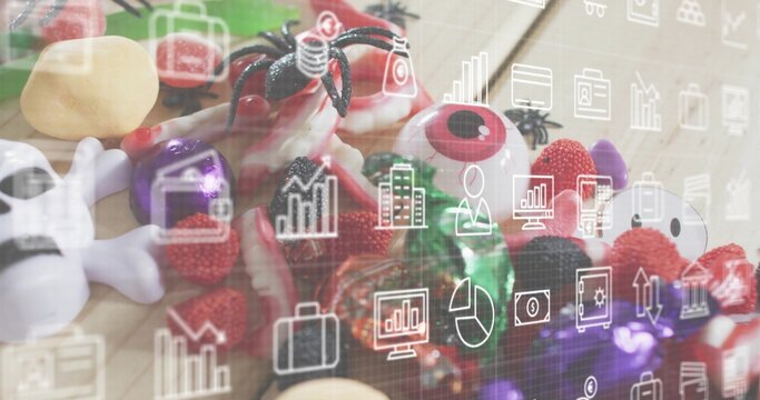 Naklejki Showing Halloween candy on wood table, with plastic eyes, skull, spider, gummies, analytics overlay