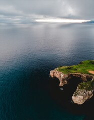 Aerial View of Coastal Rock Formation Against Calm Waters and Sky