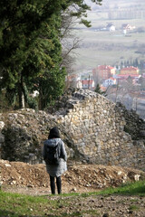 Unrecognizable person is looking at the view from the hill in Sinj, Croatia. Light snow is falling.