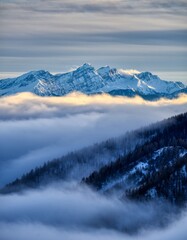 Majestic Snow-Capped Mountains Above Shrouded Fog and Clouds