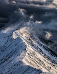 Majestic Snowy Mountain Peaks Under Dramatic Cloudy Sky