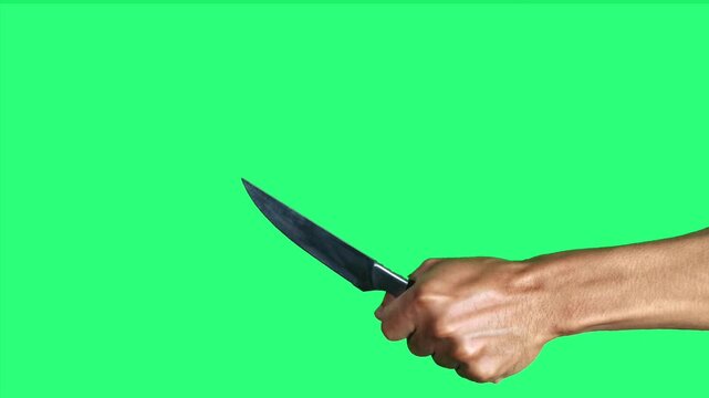 A hand holding and raising a stainless knife on a clean green screen background, suitable for visual effects, compositing, and various creative video projects