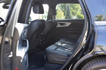 Leather rear seats with seats belt. Modern electric car interior. Rear passenger seats electric car. Leather interior design. Control unit with electric seat adjustment for rear passengers in car