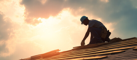 worker laying down shingles on a new roof