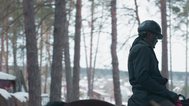single rider in black helmet forest clearing, close side profile of rider seated on dark mount, structured lesson vibe with steady pace, protective gear and focused posture, rustic barn in background,