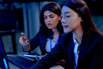 AI ethics review Female specialists collaborate late night, analyzing an AI model's performance data and code execution logs, ensuring responsible and fair deployment.
