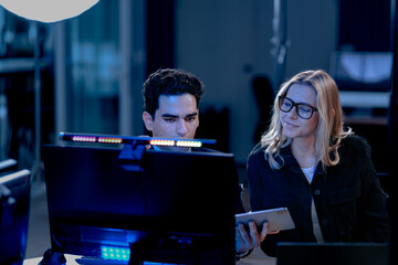 Future AI validation meeting. Human oversight lead points out discrepancies comparing AI generated report data against real time system performance displayed on control screen.