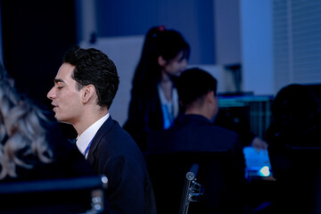 Onboarding next gen talent late night deep dive. Senior engineer guides new recruits through complex simulation code virtual environment projected screen future skills knowledge transfer learning hub.