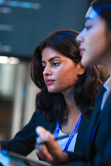 Fototapeta premium Close up profile intense focus. Young female professional deeply concentrates looking down colleague blurred foreground modern office environment serious contemplation moment captured quiet.