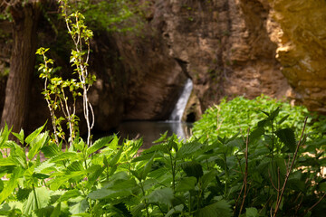 A small waterfall with a lake in the mountains.