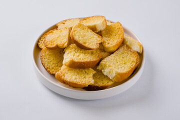 Stacked dry bread snacks served on a plate isolated on a white background.