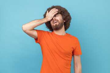 Man forgot about important meeting, punches palm on forehead, has regretting feelings.