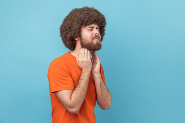 Unhealthy man touching painful neck, suffering sore throat, virus or tonsillitis.