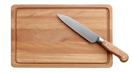A wooden cutting board with a groove around the edge and a knife lying diagonally across the board