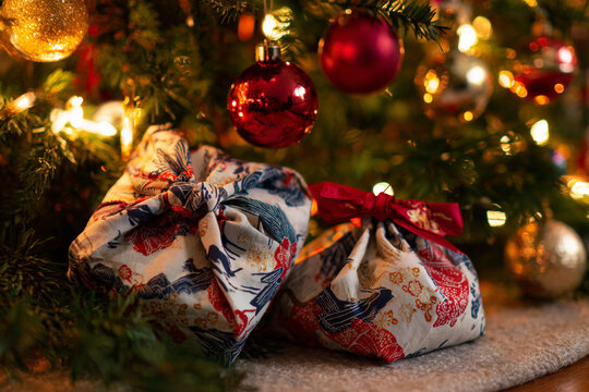 A sustainable Christmas wrapping in soft furoshiki textiles. Natural elements evoke cozy seasonal warmth. A stylish tribute to eco-friendly traditions