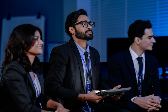 A crisis management team discusses an urgent data security threat. Diverse experts review a rapid response plan to protect customer data and ensure business continuity.