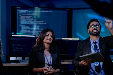A diverse team with an Indian man, Indian woman, and Caucasian man in a security awareness briefing. They are sitting and listening, learning about online safety, data protection.