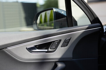 Control buttons for settings and memory of the driver's seat, electric glass opening, door handle in the interior of the new luxury electric car. Driver's seat adjustment buttons