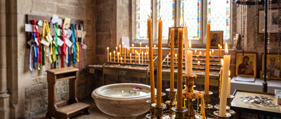 A bright, peaceful church candle area with devotional objects around.