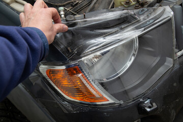 Polishing the old headlight on the car and installing a protective film
