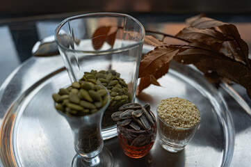 Still life with sunflower, sesame, and pumpkin seeds in glass cups