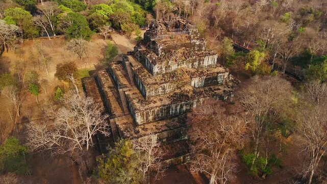Aerial view of the ancient stone pyramid of koh ker temple complex, surrounded by dry jungle forest, Cambodia.