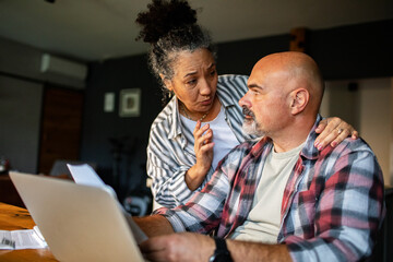 Mature wife comforting husband about finances at home