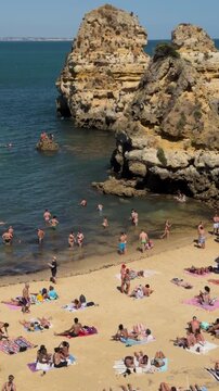 Locked-off shot of the popular Praia do Camilo beach during summer in Lagos, Algarve region, Portugal.