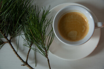 Morning cup of coffee with decor Christmas green tree with a pine cone. Ornament holiday background...