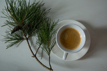 Morning cup of coffee and decor Christmas green tree with a pine cone. Ornament holiday background,...